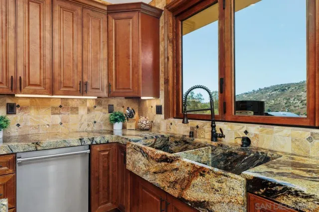 a kitchen with stainless steel appliances granite countertop a sink stove and cabinets