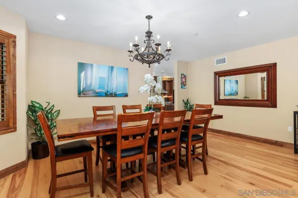 a view of a dining room with furniture a chandelier and wooden floor