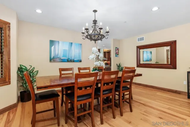 a view of a dining room with furniture a chandelier and wooden floor