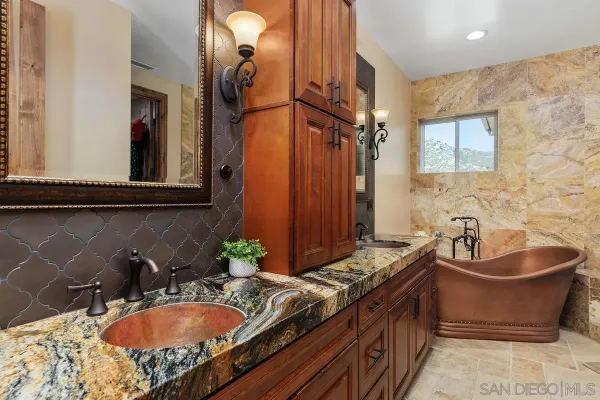 a bathroom with a granite countertop sink and a mirror