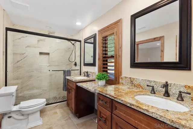 a bathroom with a granite countertop sink toilet and shower