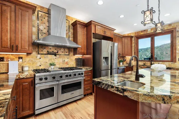 a kitchen with granite countertop a stove and a refrigerator