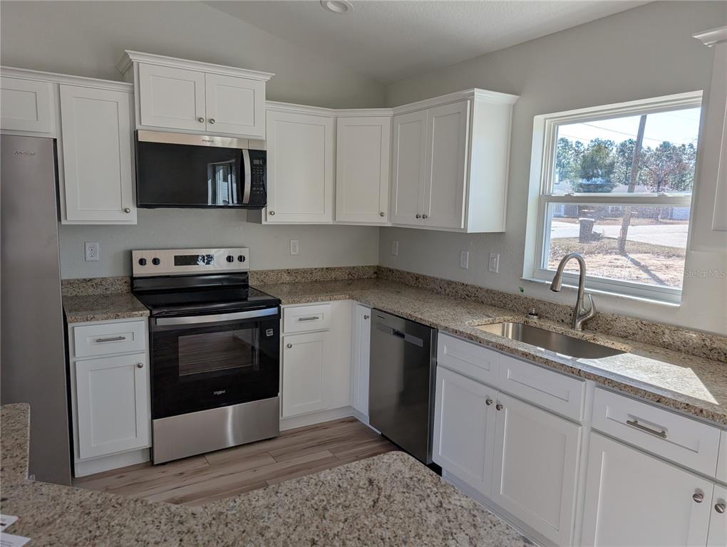 37 Fir Drive Trace Ocala, FL 34472 - Photo 10 of 31 a kitchen with granite countertop white cabinets stainless steel appliances and a window