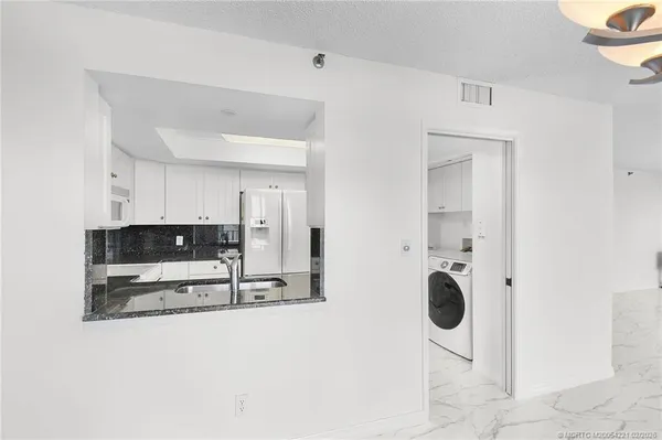 a view of kitchen with sink and refrigerator