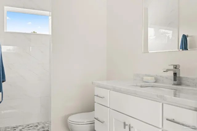 a bathroom with a toilet sink vanity and mirror