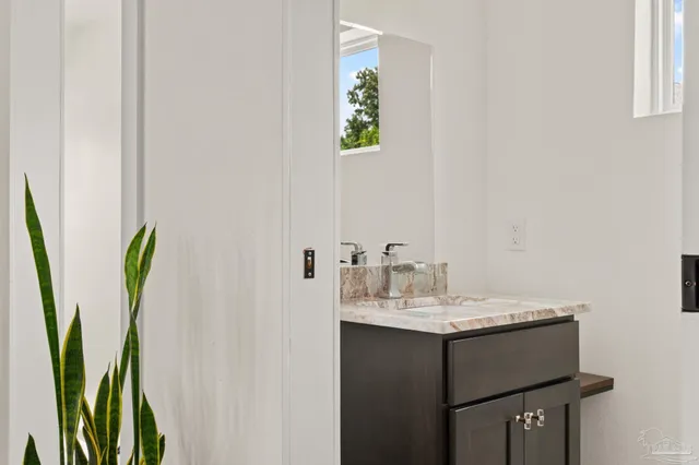 a bathroom with a sink a mirror and a painting on the wall