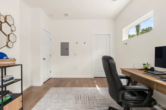 a view of a workspace with furniture and wooden floor