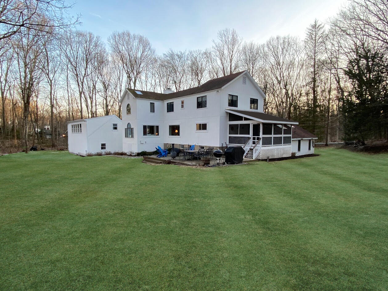 149 Journeys End Road Wilton, CT 06897 - Photo 3 of 30 a front view of a house with a garden and trees