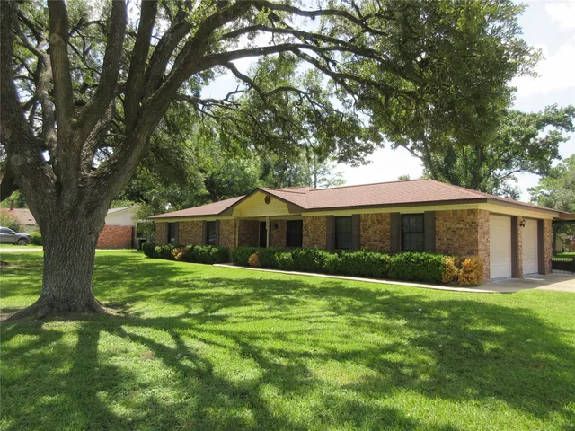 a front view of a house with yard and green space