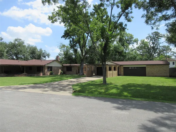 a front view of a house with a yard and trees