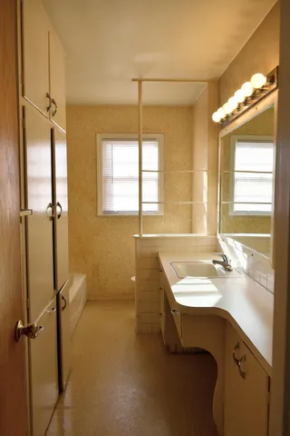 a bathroom with a tub sink and mirror