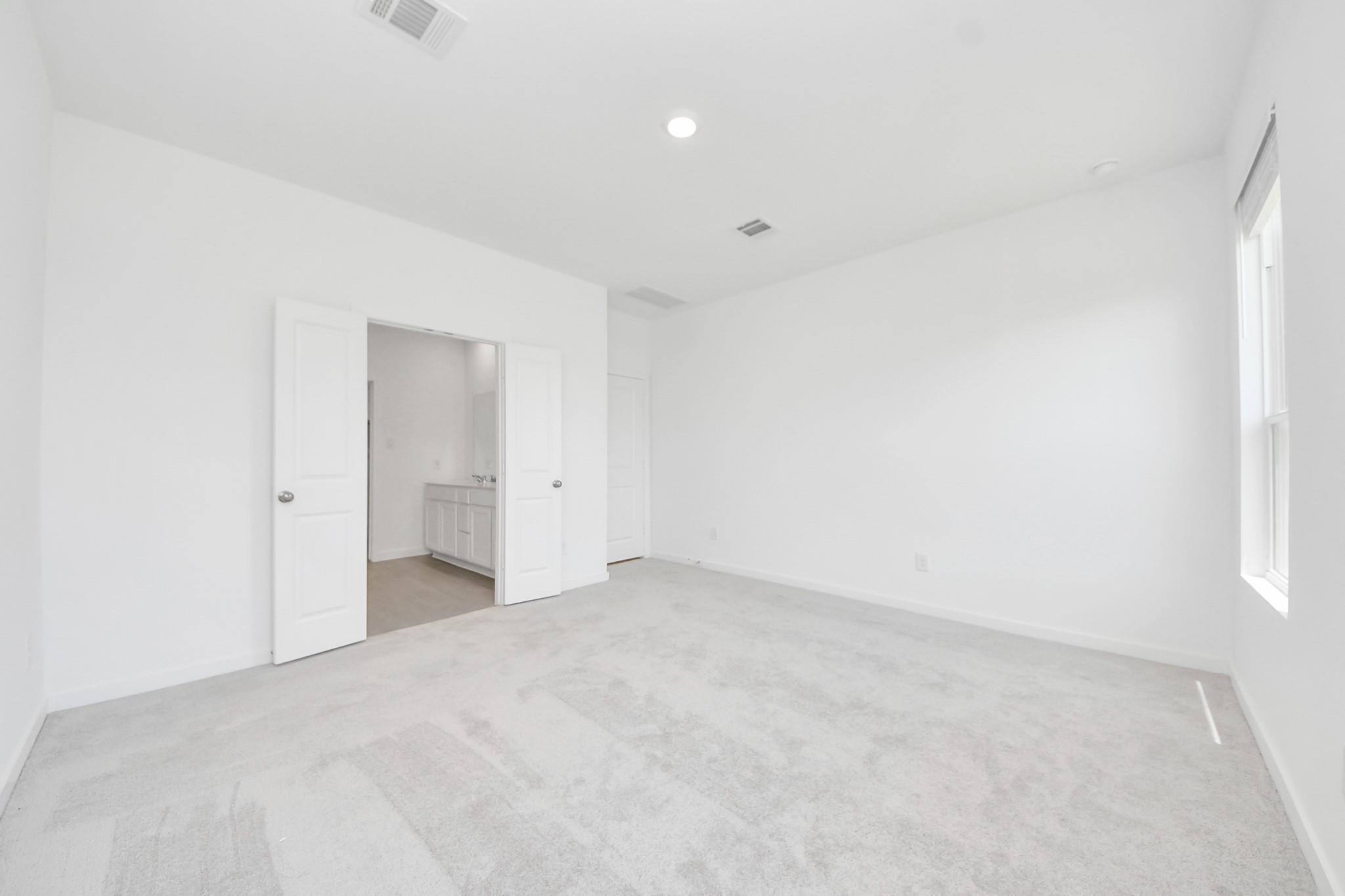 10650 Ellerston Road Cleveland, TX 77327 - Photo 12 of 25 Primary bedroom offers a full en-suite bathroom, complete with double doors that add a touch of luxury and provary
