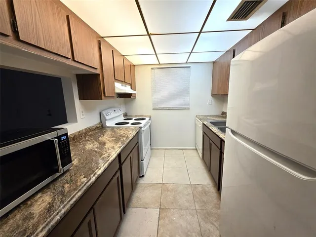 a kitchen with stainless steel appliances granite countertop a stove and a refrigerator