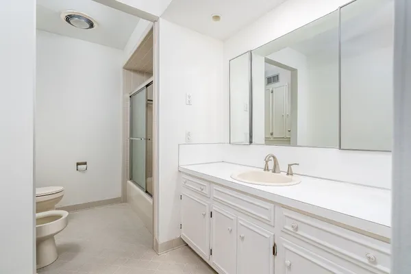 a bathroom with a sink a toilet and a mirror