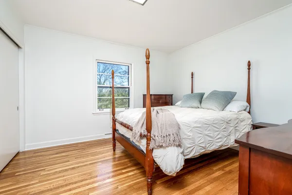 a bedroom with a bed and wooden floor