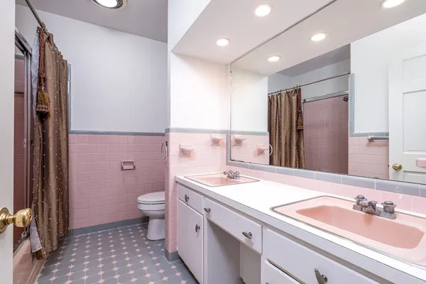 a bathroom with a sink a toilet a mirror and shower