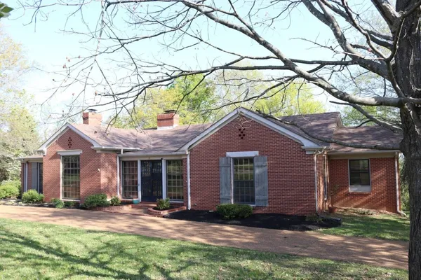 a front view of a house with yard and green space