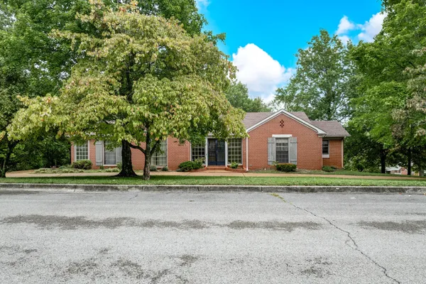 a front view of a house with a yard and trees