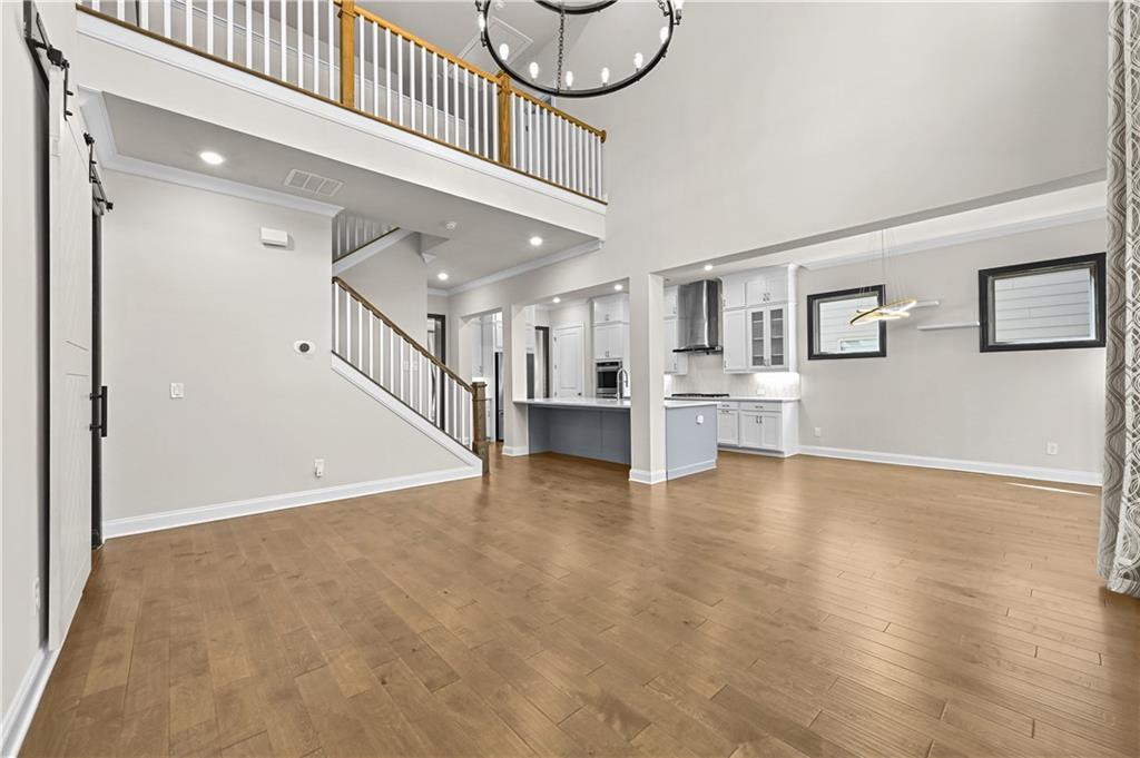 3475 Benedict Place Suwanee, GA 30024 - Photo 11 of 42 a view of a livingroom with wooden floor and stairs