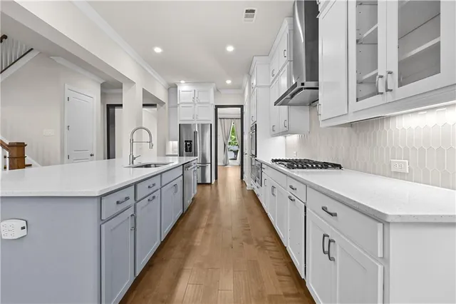 a large kitchen with stainless steel appliances lots of counter space wooden floor and cabinets