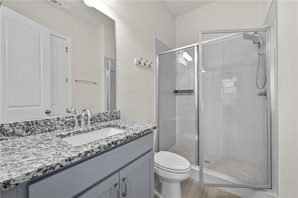 3475 Benedict Place Suwanee, GA 30024 - Photo 22 of 42 a bathroom with a granite countertop sink toilet and shower