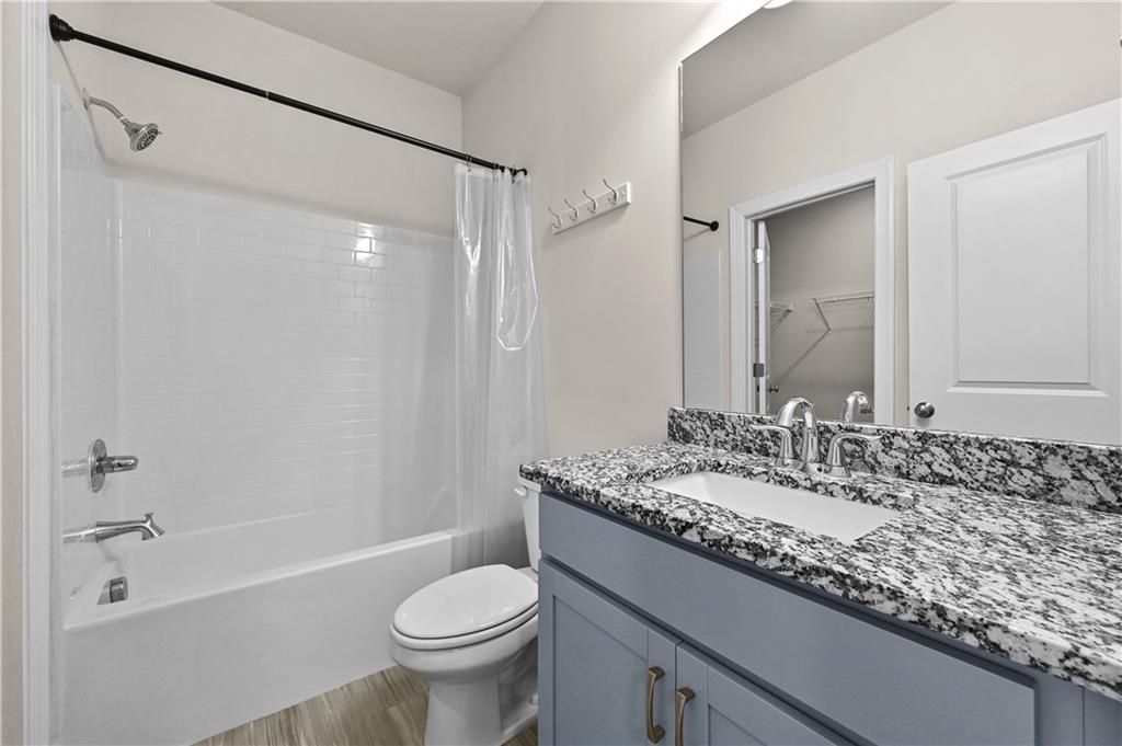3475 Benedict Place Suwanee, GA 30024 - Photo 26 of 42 a bathroom with a granite countertop sink toilet and shower