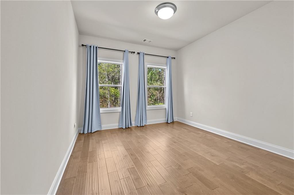 3475 Benedict Place Suwanee, GA 30024 - Photo 27 of 42 an empty room with wooden floor and windows