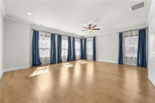 a view of an empty room with window and a kitchen