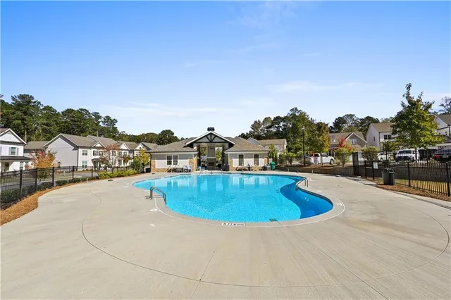 a view of a swimming pool with a patio and a yard