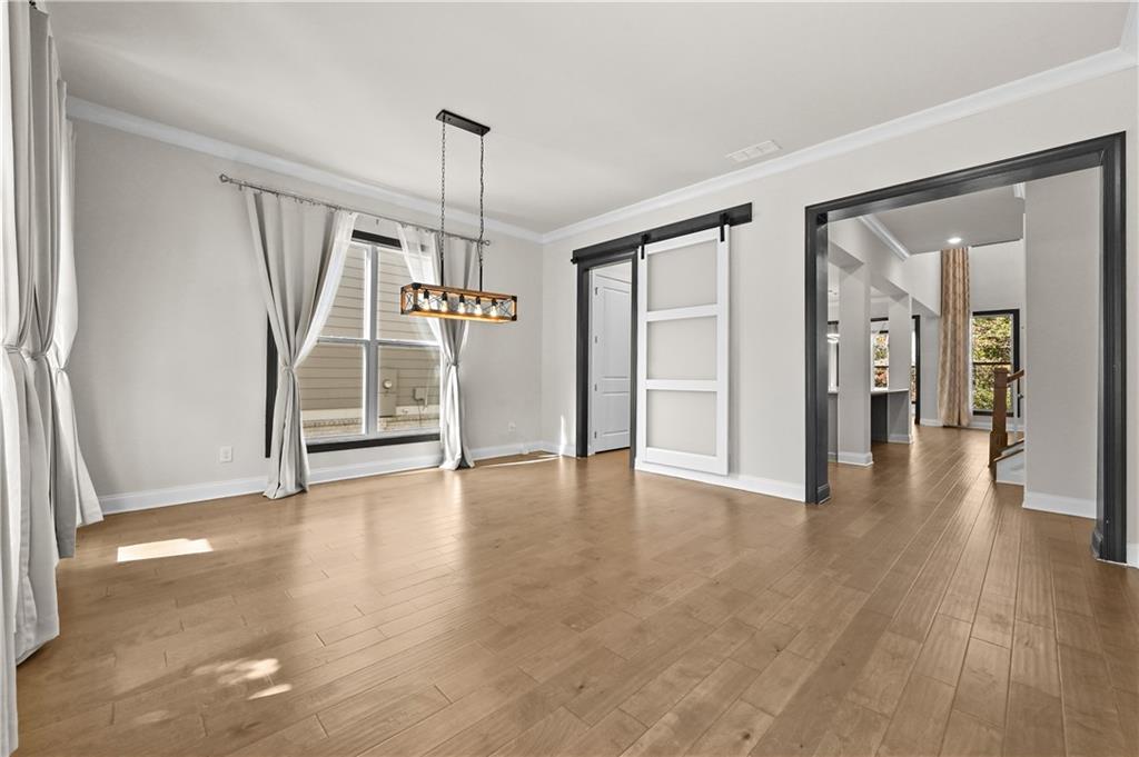 3475 Benedict Place Suwanee, GA 30024 - Photo 6 of 42 a view of an empty room with wooden floor and a window