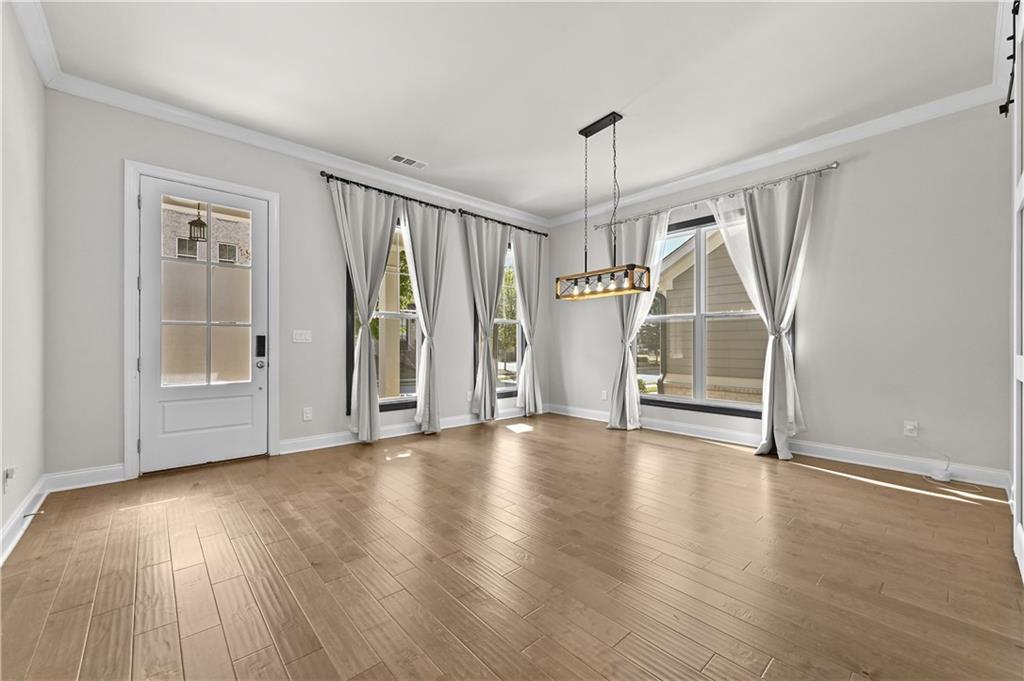 3475 Benedict Place Suwanee, GA 30024 - Photo 7 of 42 an empty room with wooden floor and windows