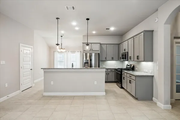 a large kitchen with stainless steel appliances lots of counter space sink and cabinets