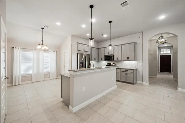 a large kitchen with cabinets and stainless steel appliances