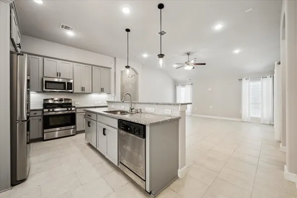 a kitchen with kitchen island stainless steel appliances a stove a sink and a refrigerator