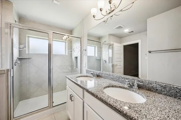 a bathroom with a granite countertop sink a mirror and shower
