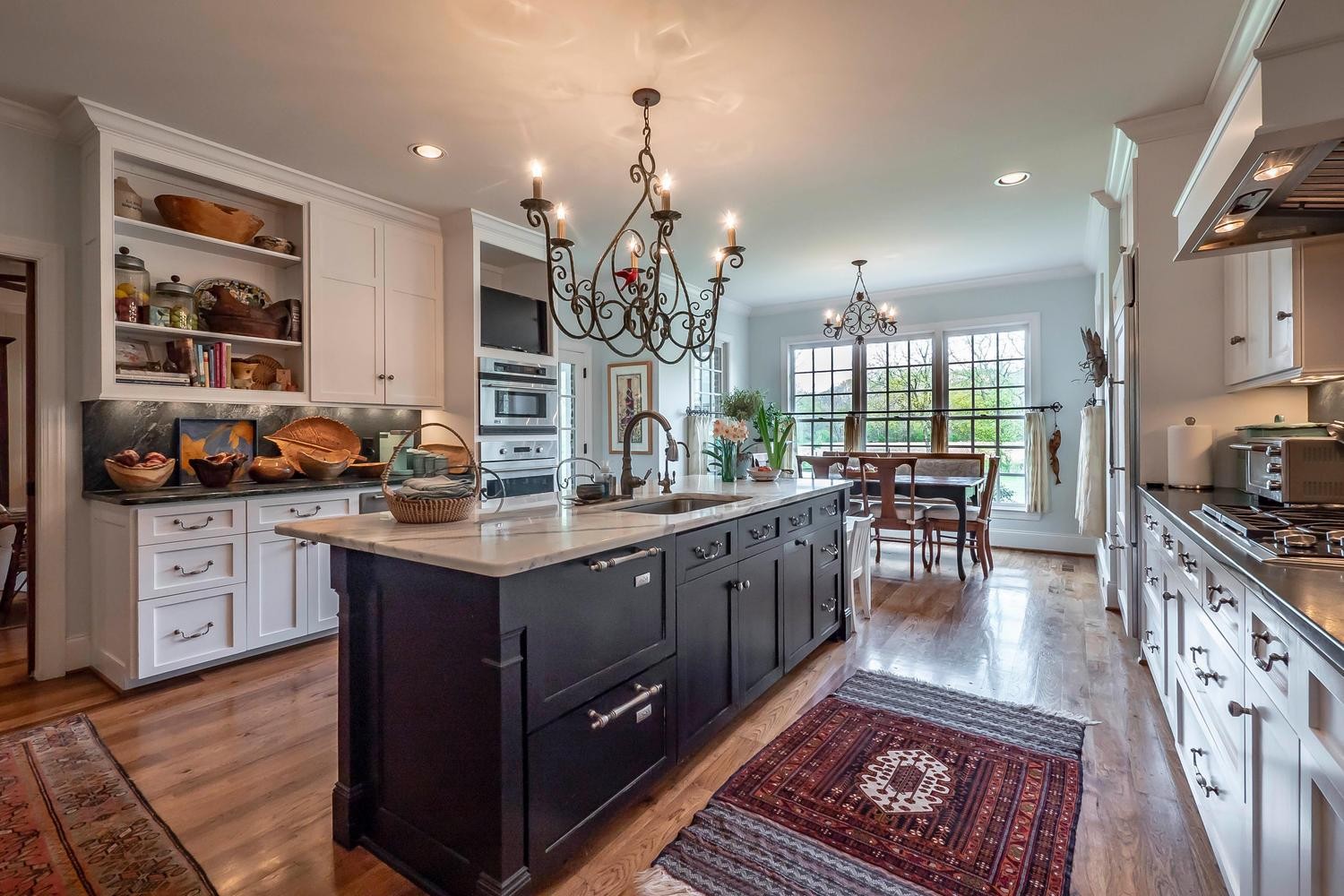 5178 Old Harding Road Franklin, TN 37064 - Photo 10 of 26 a kitchen with stainless steel appliances granite countertop a stove a sink dishwasher a living room with couches wooden floor and a dining table with kitchen view