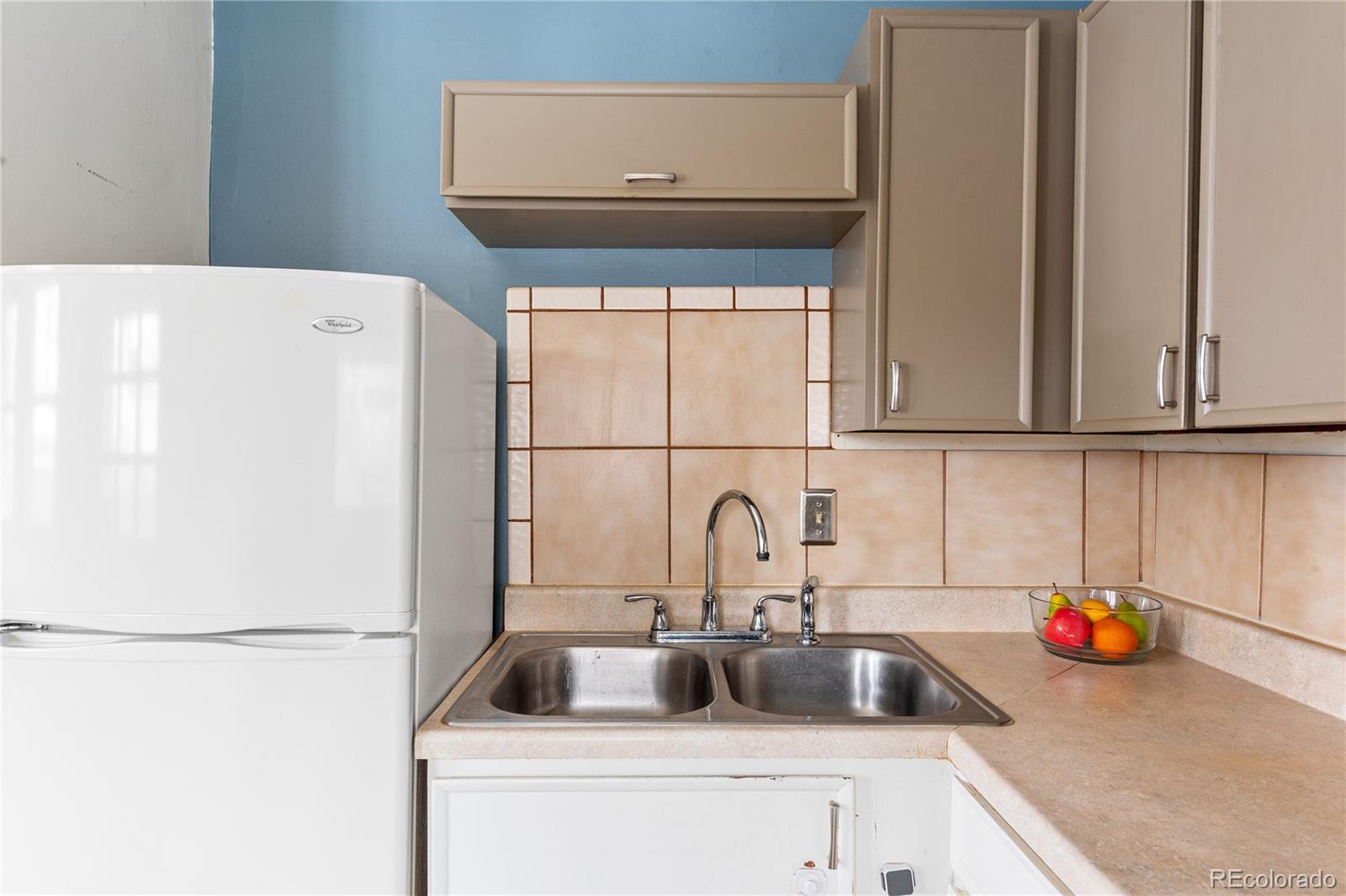 4151 Zenobia Street Denver, CO 80212 - Photo 16 of 31 a kitchen with a sink and a refrigerator