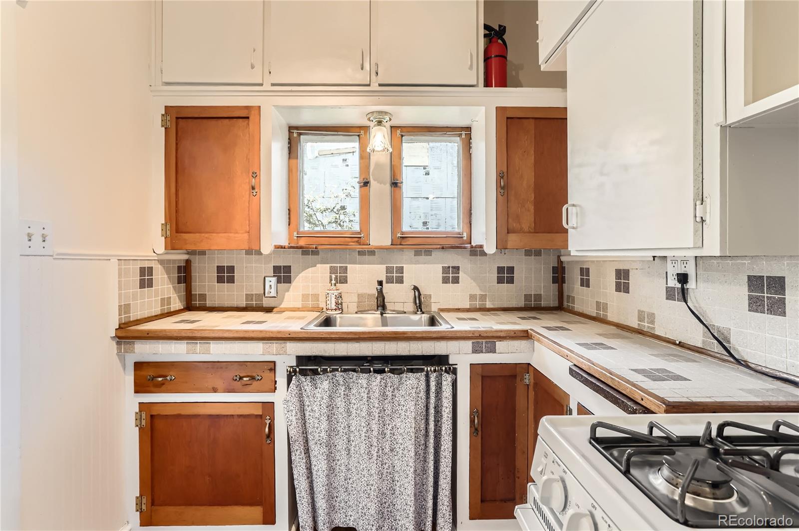 4151 Zenobia Street Denver, CO 80212 - Photo 27 of 31 a kitchen with a sink stove and cabinets