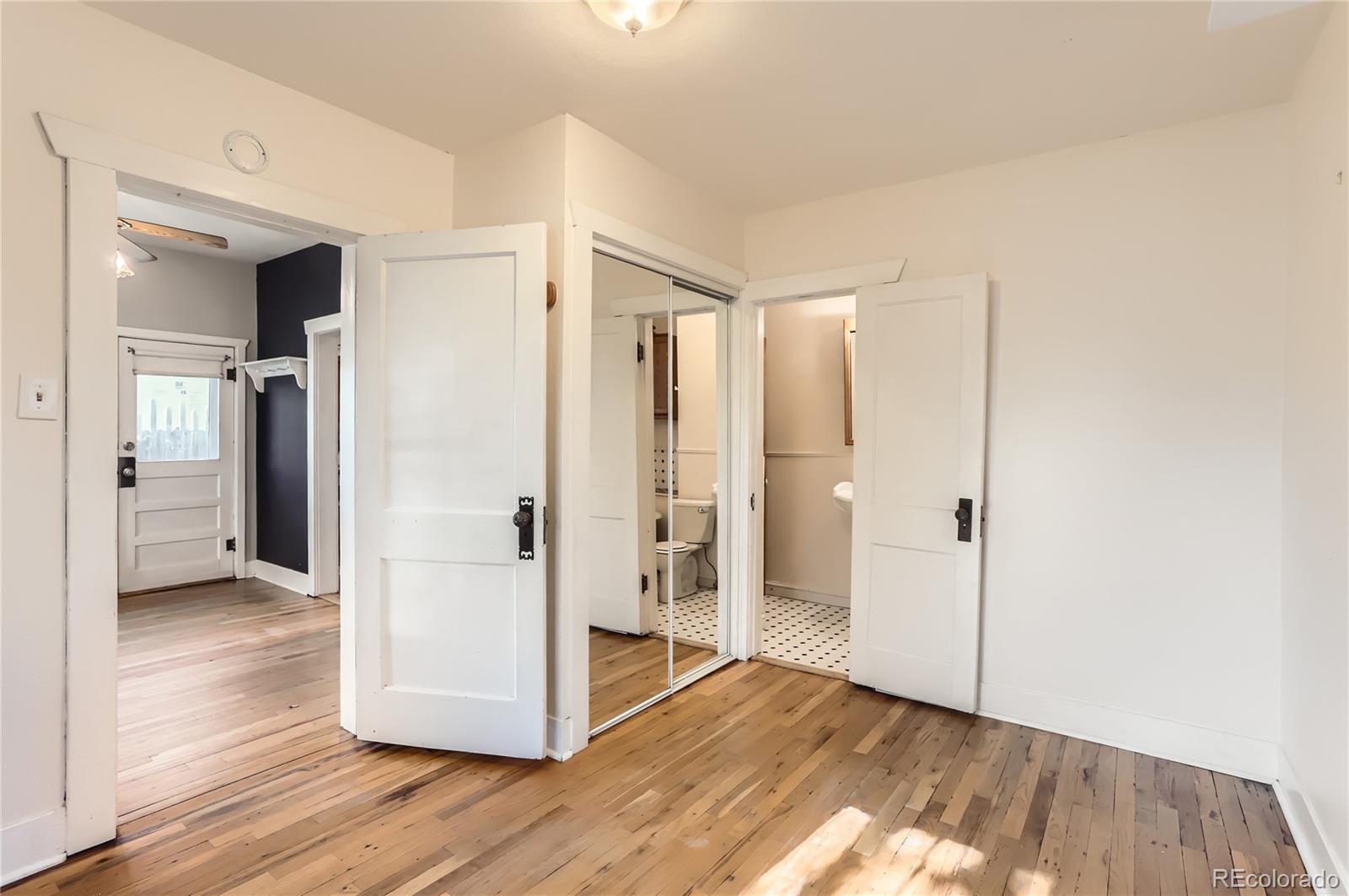 4151 Zenobia Street Denver, CO 80212 - Photo 30 of 31 a view of an empty room with wooden floor and a bathroom