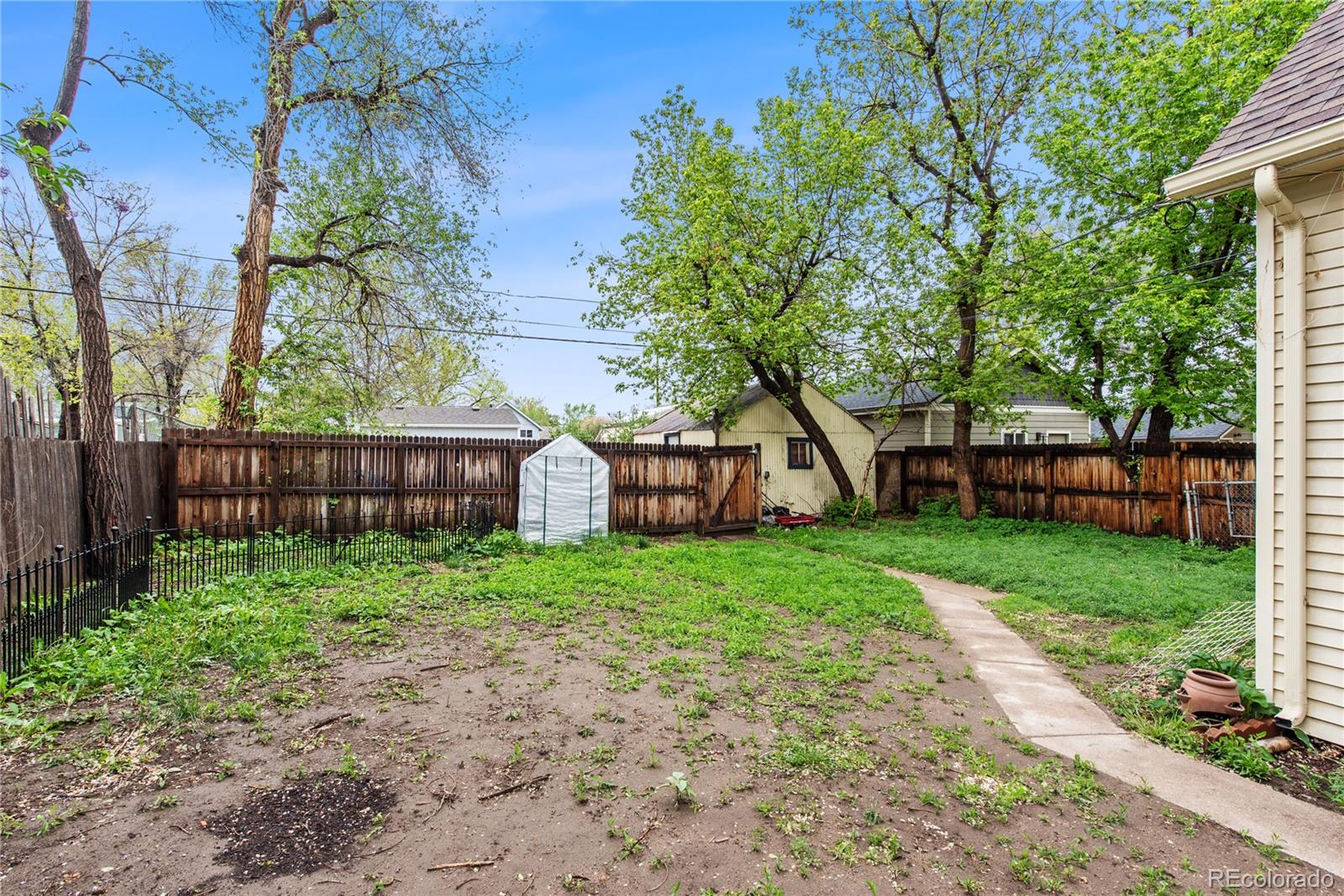 4151 Zenobia Street Denver, CO 80212 - Photo 6 of 31 a view of a wooden house with a big yard and large trees