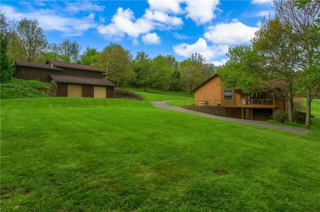 481 Chicora Fenelton Road Chicora, PA 16025 - Photo 39 of 50 Rear grounds view showcasing the open lawn, mature trees, and tranquil backyard setting.