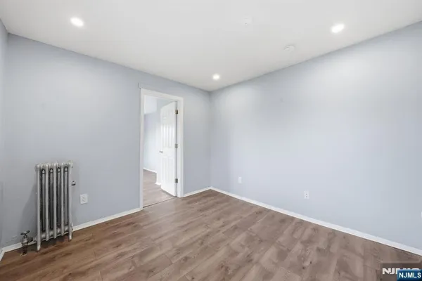 a view of empty room with wooden floor and ceiling fan