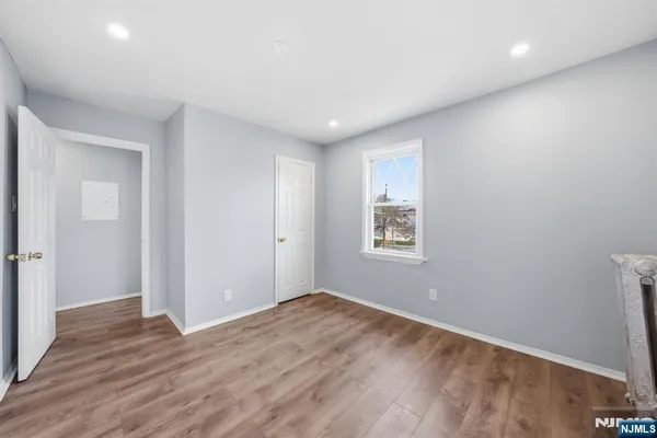 a view of an empty room with a window and a ceiling fan