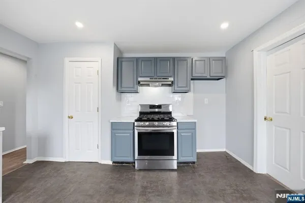 a large white kitchen with cabinets a sink a window and a fireplace