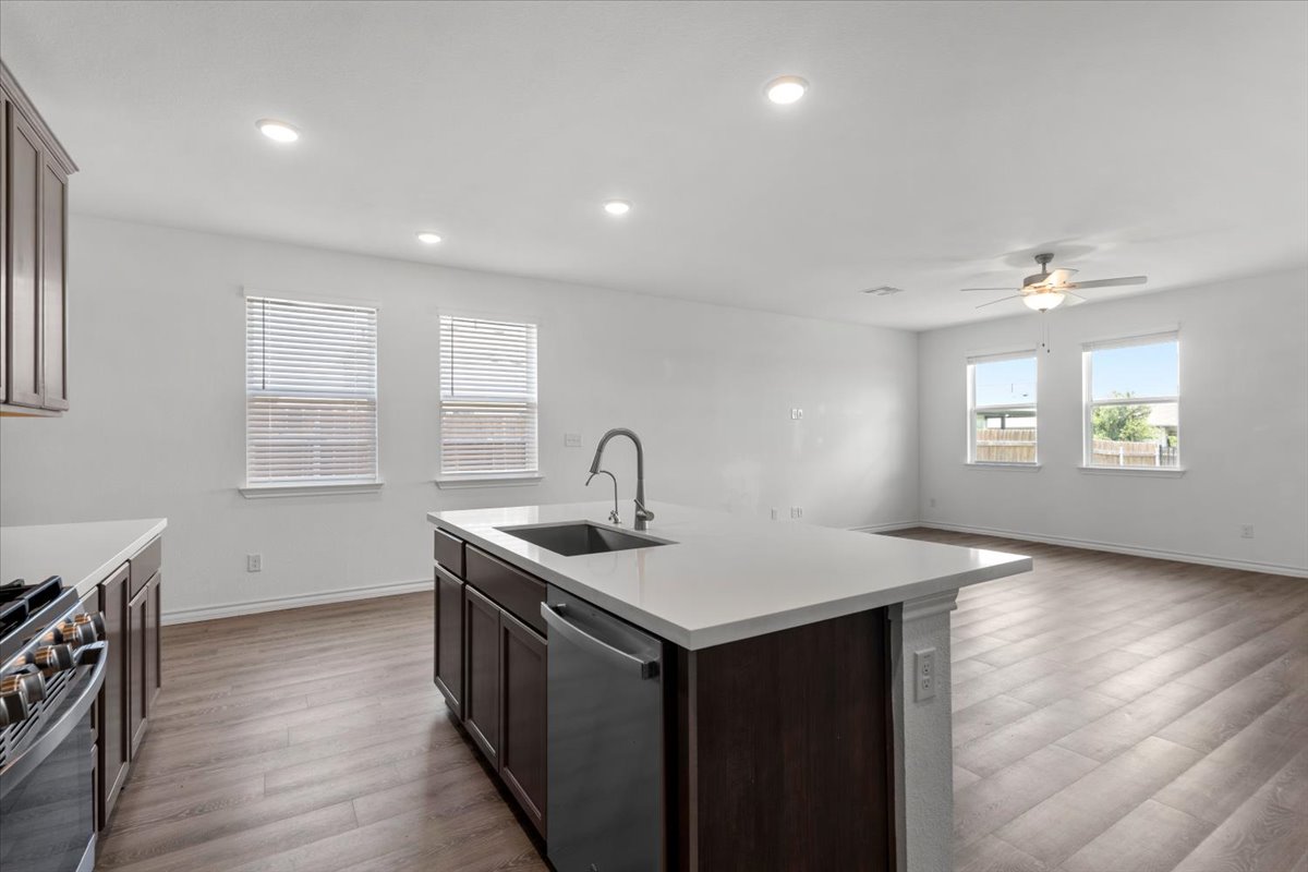 500 Stinchcomb Road Hutto, TX 78634 - Photo 18 of 37 A contemporary kitchen space boasts an inviting island with a sink and gleaming stainless steel appliances.