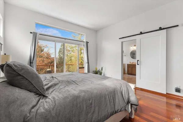 a large bed sitting in a bedroom next to a window