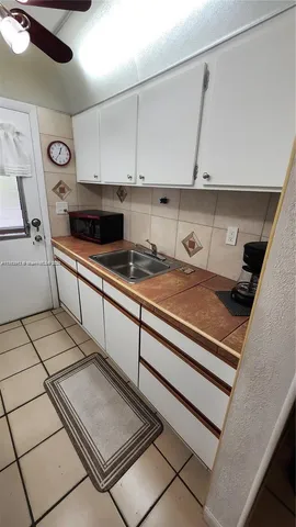 a kitchen with a sink a stove and cabinets