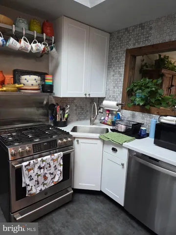 a kitchen with stainless steel appliances granite countertop a stove a sink and cabinets
