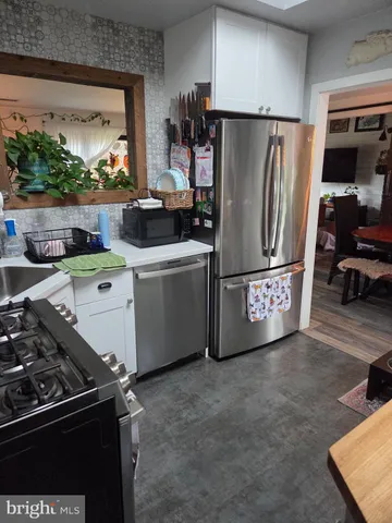 a kitchen with stainless steel appliances granite countertop a refrigerator and a stove