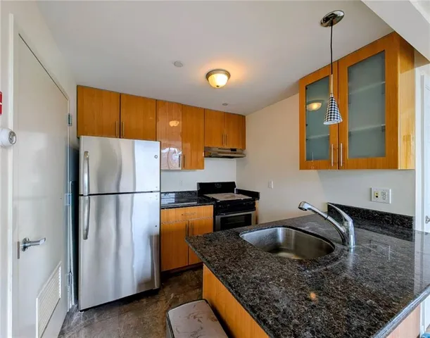 a kitchen with stainless steel appliances granite countertop a sink refrigerator and microwave